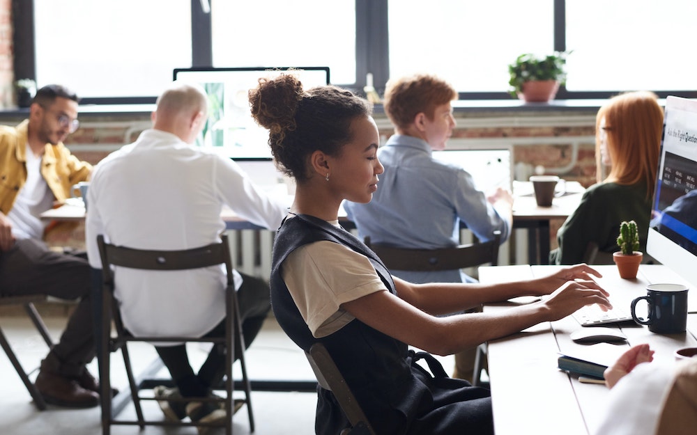 A photo of employees working on laptops could be related to discussing about how SEO Can Influence and Optimize Email Marketing